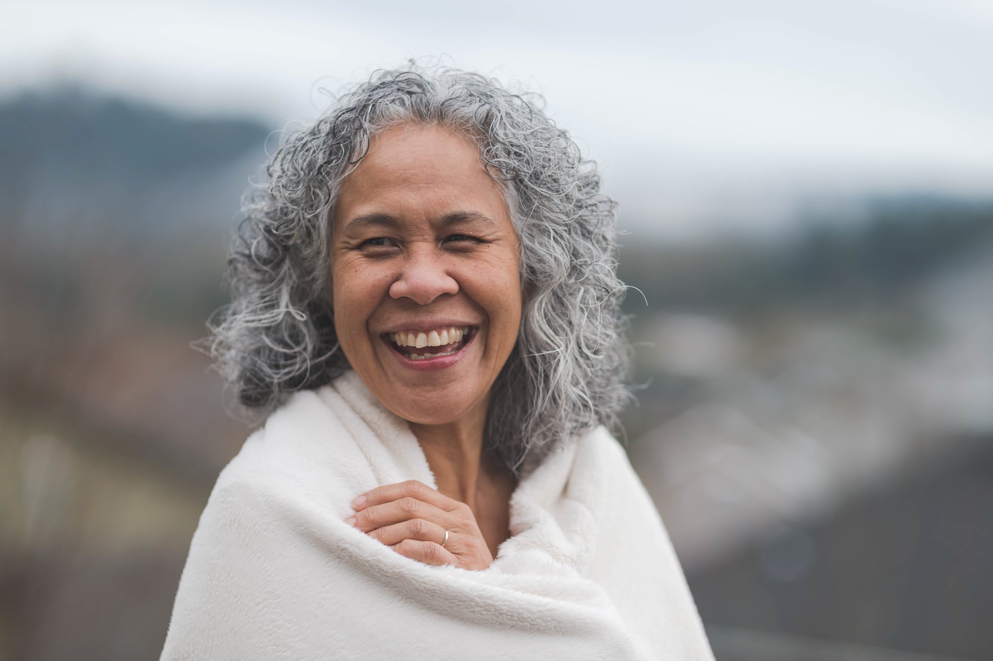 Cute Hawaiian woman in 50s outside smiling at camera joyfullyl